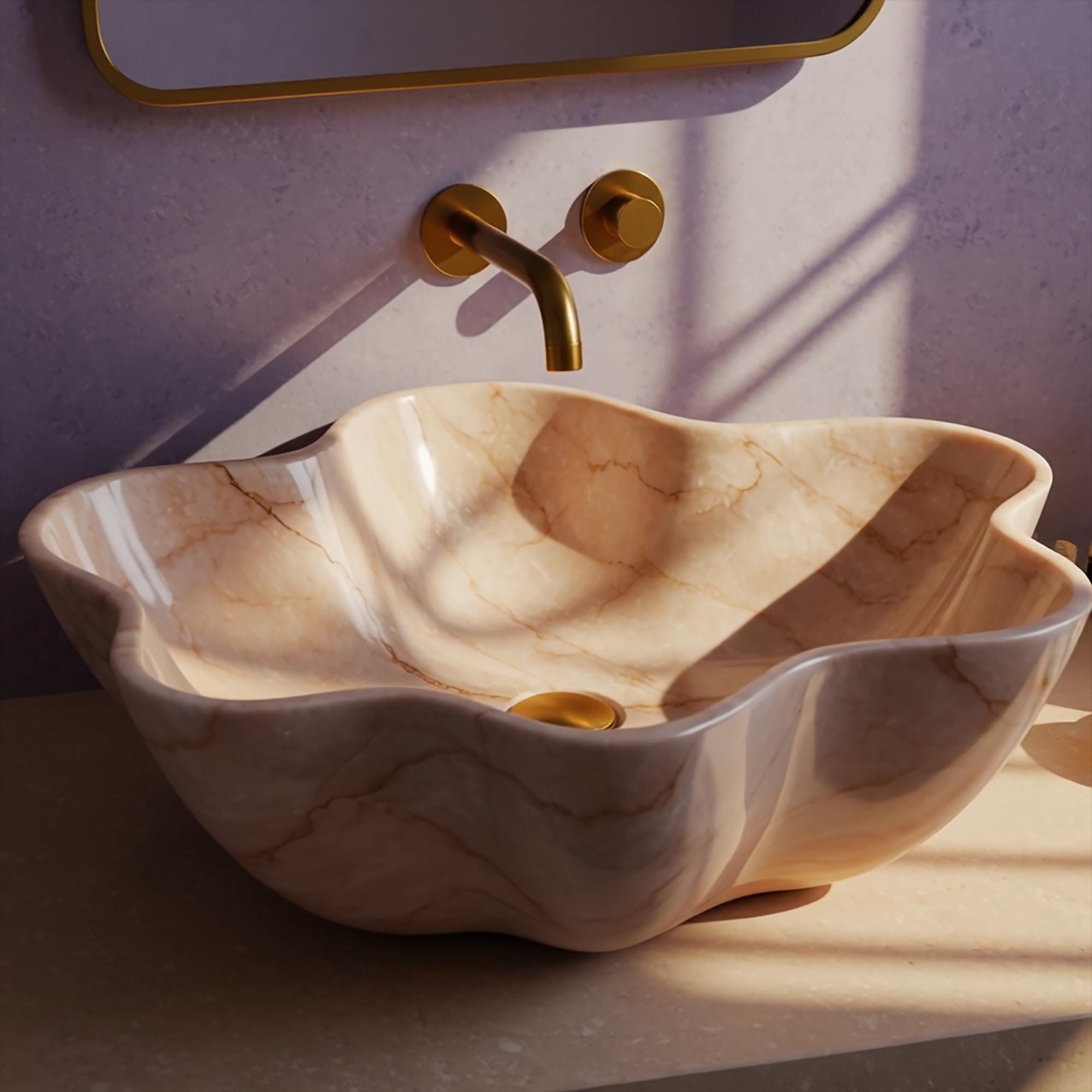 A handcrafted pink marble sink shaped like a flower, with soft organic lines and a luxurious golden faucet.