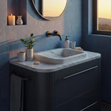 A floating Carrara marble vanity with a soft-edged integrated basin and modern wall-mounted faucet.