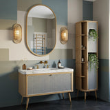 This elegant vanity features a Carrara marble top, natural oak wood, and a woven cane front, perfect for a luxury powder room.