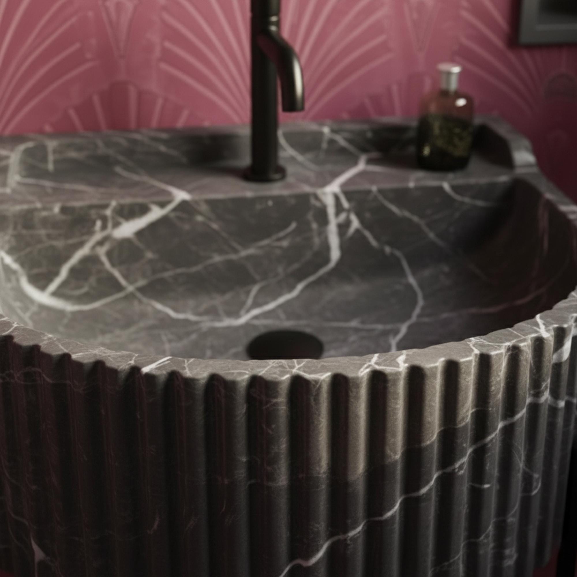 Sculptural black marble sink with vertical grooves and black hardware, designed for high-end residential powder rooms.