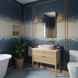 This travertine marble vessel sink rests on a cane-drawer vanity, combining luxury stone with warm, natural textures.